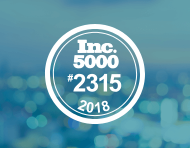 A circular badge with the text Inc. 5000 #2315 2018 on a blurred blue background, indicating a company’s ranking on the 2018 Inc. 5000 list.