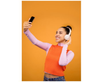 woman with headphones and looking at phone