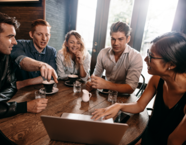 Group of young professionals discussing client on laptop