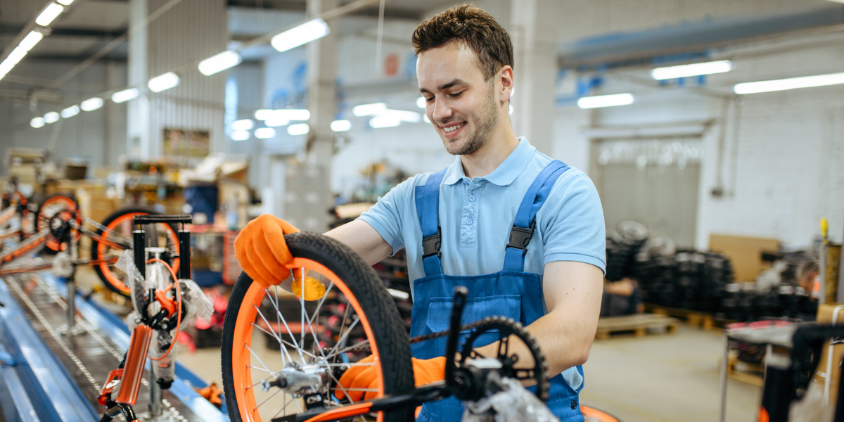 man assembling bike in manufacturing facility
