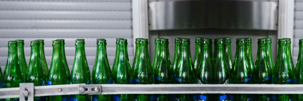 green glass bottles on an assembly line