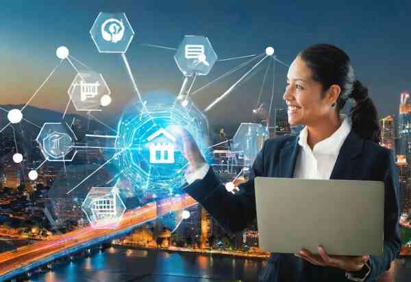 A businesswoman smiles while using a laptop and interacting with virtual icons related to real estate, technology, and AI in eCommerce, set against a cityscape background at night.